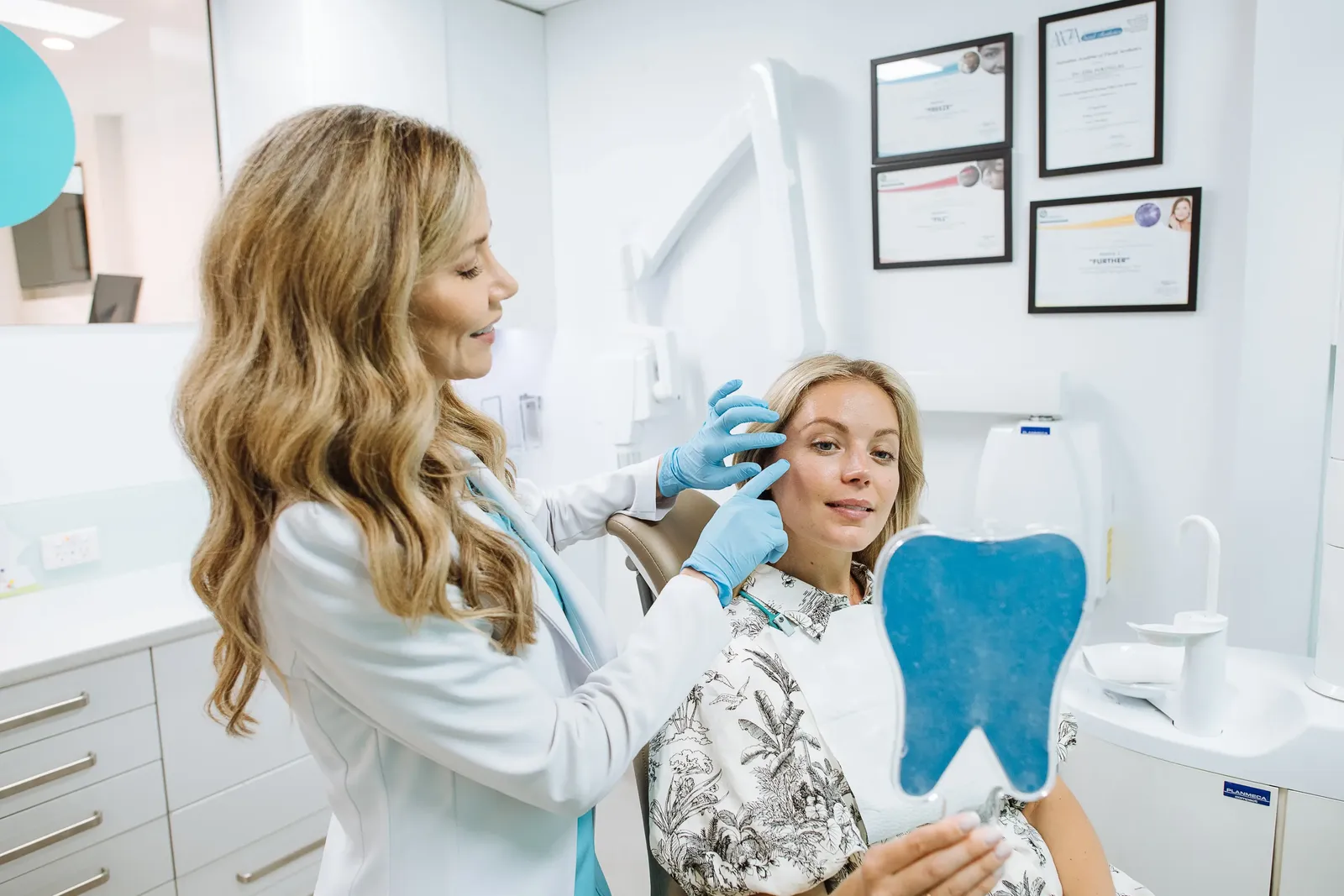 Dr Ellie Montero with a patient holding a model tooth