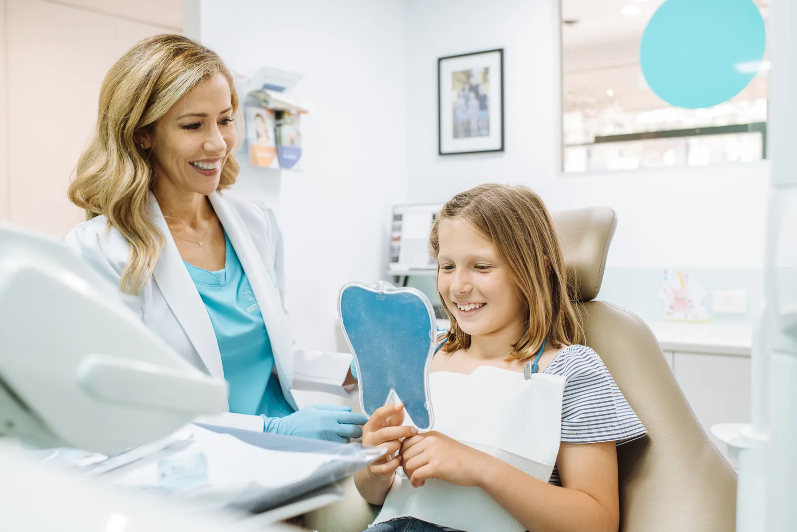 Dr Ellie Montero with a young patient holding a model tooth