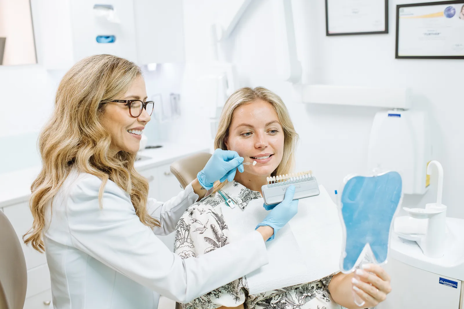 Dr Ellie Montero showing a patient her tooth shade on a shade guide